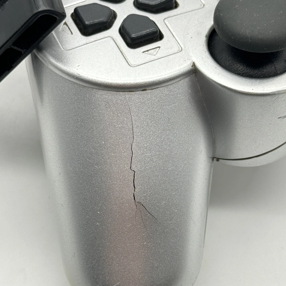Playstation 2 ovládač (strieborný, popraskaný)